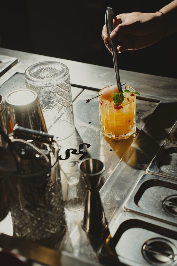 Bartender meracik sentuhan akhir minuman di bar The Social Solitude